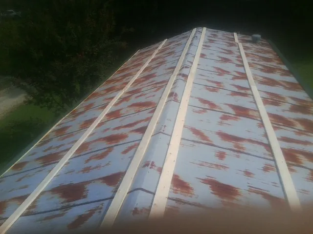 Rusted metal roof panels with new wood purlins before replacement — Storm Damage Roof Repair in Tuskegee Institute by Roofing Brothers